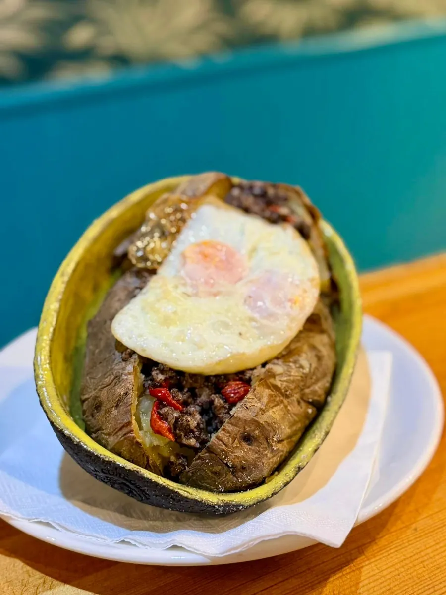 Patata Baturra de La Cordobesa, con morcilla, piquillo y huevo en su cuenco negro y verde